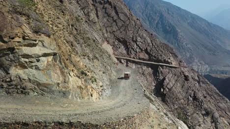 Luftaufnahme-Eines-Fahrzeugs-Auf-Der-Fee-Wiese-Straße-In-Pakistan,-Zweit-Tödlichste-Autobahn-Der-Welt,-Rotierender-Breiter-Drohne-Schuss