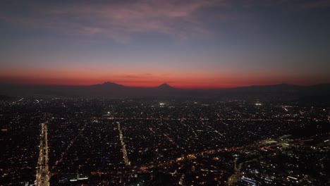 Calm,-Serene-Sunset-and-Nightfall-over-Mexico-City-Lights,-Aerial-Drone