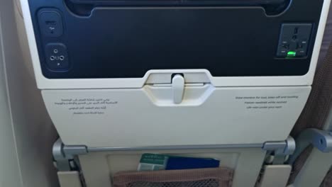 Hand-folds-up-table-of-an-economy-plane-seat