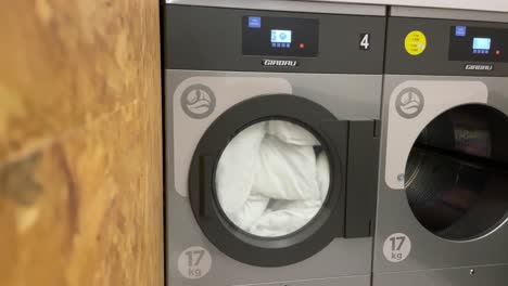 Front-load-washing-machine-spinning-clothes-during-wash-at-the-laundry