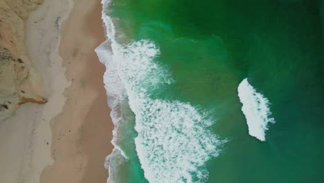 Aerial-view-drone-shot-pan-up-of-rock-cliffs-on-California-Coastline