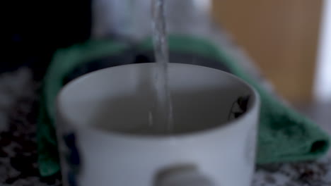 Pouring-water-in-cup-for-morning-tea,-close-up-static-view