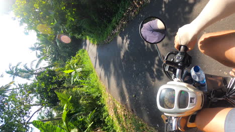 Vertikale-Aufnahme-Eines-Mannes,-Der-An-Einem-Sonnigen-Tag-In-Indonesien-Auf-Einem-Roller-Durch-Bali-Reist