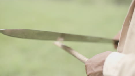 Slow-motion-close-footage-of-a-person-chopping-on-a-stick-to-make-a-spear