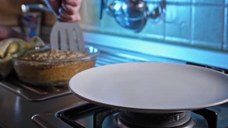 Cutting-Home-Baked-Chicken-And-Oatmeal-Dish-Using-Slotted-Turner-In-The-Kitchen-To-Serve-In-A-Plate