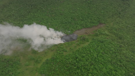 Aerial-footage-rotating-over-a-forest-fire-in-rural-Sierra-Leone,-Africa