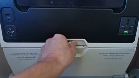 POV-folding-down-a-tray-table-on-a-plane-one-handed