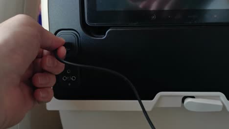 Plugging-a-USB-device-into-the-seat-of-an-economy-class-seat