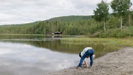 A-boy-plays-on-front-of-the-lake-river-in-Norway