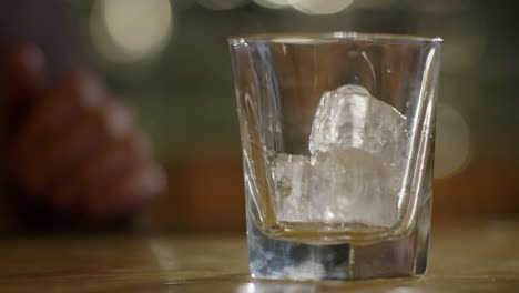 Slow-Motion-Shot-Of-Pouring-Whiskey-Into-Glass-With-Ice-Cubes
