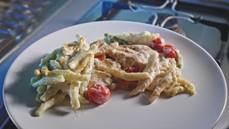 Cheesy-Chicken-And-Pasta-With-Cherry-Tomatoes-Served-In-A-Plate