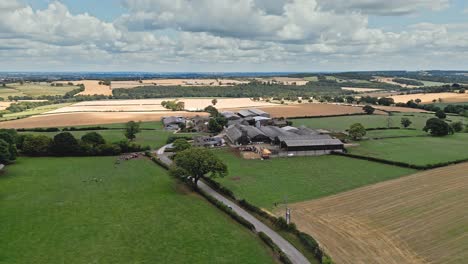 Aerial-footage-of-a-modern-day-farm-and-out-buildings-in-a-rural-Yorkshire-landscape,-shot-in-Emley-Village-West-Yorkshire