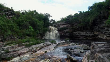 4K-Aufnahme-Nach-Oben-Kippen,-Die-Den-Atemberaubenden-Teufelsgrubenwasserfall-Enthüllt,-Umgeben-Von-Laub-Und-Felsen-An-Einem-Bewölkten-Regnerischen-Tag-Im-Berühmten-Nationalpark-Chapada-Diamantina-Im-Nordosten-Brasiliens