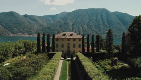 Flying-across-the-front-garden-over-the-roof-tilting-down-to-reveal-seated-backyard-in-front-of-the-lake-seated-up-for-a-wedding-of-famous-Villa-Balbiano-at-lake-como-Ossuccio-in-italy