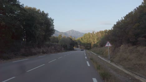 Conducir-Un-Automóvil-En-La-Carretera-Costera-De-Córcega-Durante-La-Luz-Del-Atardecer