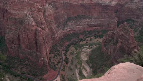 Zion-Canyon-national-park-and-the-Virgin-River-below-between-tall-cliffs,-Pan-left-reveal-shot