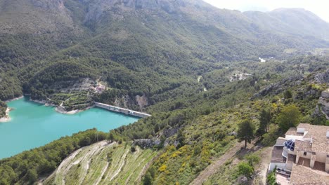 Guadalest-valley,-mountains-and-stunning-blue-lake-with-birds-flying-past