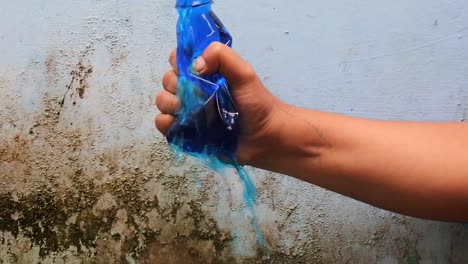 Drücken-Sie-Die-Mit-Blauer-Flüssigkeit-Gefüllte-Flasche-Mit-Der-Hand-Zusammen