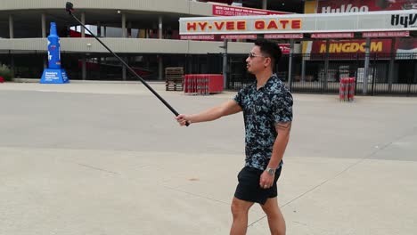 man-walks-with-selfie-stick-in-front-of