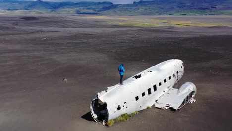 Man-standing-on-a-plane-wreck-in-iceland
