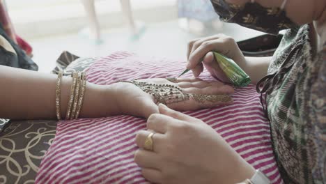 Henna-Künstler,-Der-Mehndi-Auf-Die-Handfläche-Der-Braut-Aufträgt-Und