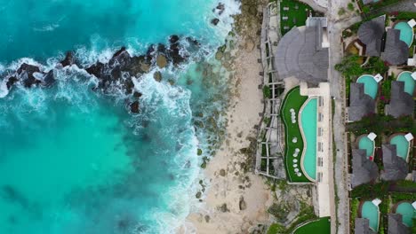 beautiful-infinity-pool-overlooking-turquoise-tropical-waves-crashing