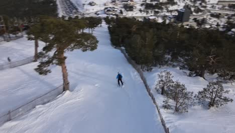 Aerial-top-down-view-following-skier-from-behind-going