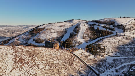 Park-City-Utah-Aerial-v18-beautiful-winter-landscape,-drone-uphill-flyover-deer-valley-resort-hilltop-ski-lodge-capturing-pristine-and-idyllic-mountain-view---Shot-with-Mavic-3-Cine---February-2022