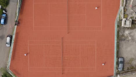 Tennis-Players-During-A-Match-On-Red-Tennis-Courts-In-The-Outdoor-At-Daytime