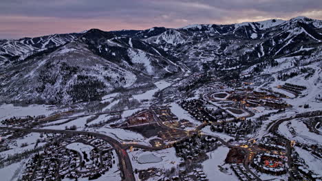 Park-City-Utah-Aerial-v30-cinematic-pan-shot-capturing-tranquility-of-the-mountain-town-surrounded-by-snowy-white-mountainous-landscape-at-sunset-dusk---Shot-with-Mavic-3-Cine---February-2022