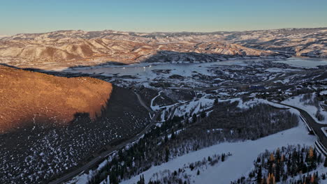 Park-City-Utah-Aerial-v21-cinematic-flyover-capturing-beautiful-snowy-mountainscape-and-pristine-winter-landscape-with-frozen-jordanelle-reservoir-at-sunset---Shot-with-Mavic-3-Cine---February-2022