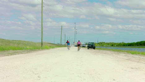 Two-Bicyclists-riding-past-camera-dirt-ride-canal