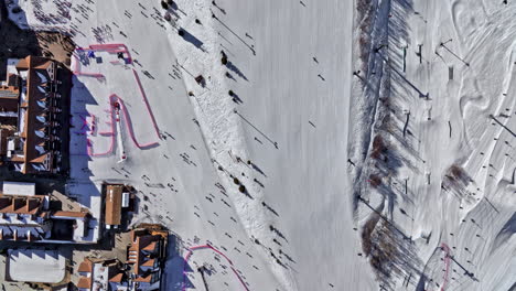 Park-City-Utah-Aerial-V60-Draufsicht-über-Skipisten,-Die-Winterurlaubshütten-Und-Bewegungen-Von-Seilbahnliften-Und-Freestyle-Skifahren-Und-Snowboarden-Einfangen-–-Aufgenommen-Mit-Mavic-3-Cine-–-Februar-2022