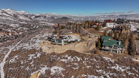 Park-City-Utah-Aerial-v64-fly-around-hilltop-luxury-vacation-homes-capturing-surrounding-mountain-ranges-covered-in-snow-and-townscape-of-foothill-neighborhood---Shot-with-Mavic-3-Cine---February-2022