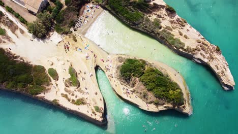 Corfu-island-Greece-aerial-top-down-tourist-beach-summer-holiday-scenic-cliff-with-pristine-sea-water