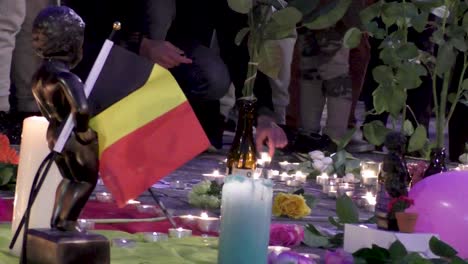 Menschen,-Die-Nach-Den-Terroranschlägen-Von-Brüssel-Tribut-Zollen---Kerzen,-Blumen,-Manneken-Pis-Statue-Mit-Belgischer-Flagge---22