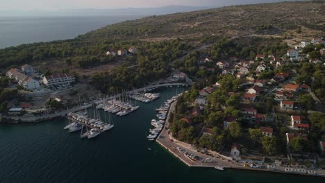 Aerial-orbit-shot-of-a-secondary-port-in-Milna,-Brac-Island,-Croatia-at-sunset-with-scenic-view-over-the-turquoise-water-of-Adriatic-Sea