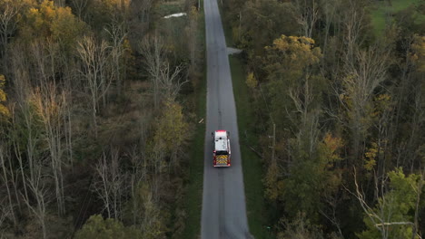 Emergency-Fire-Truck-Vehicle-Driving-Fast-along-Straight-Countryside-Road-with-Flashing-Lights,-Rescue-First-Responder-Mission-for-Fire-Fighting-Alert,-Path-Route-Through-Nature-Lands-and-Trees