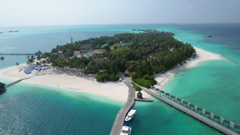 Vista-Aérea-De-La-Isla-Tropical-De-Maldivas-Con-Barcos,-Piscina,-Playa-Y-Edificios-Sobre-El-Agua