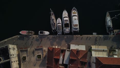 Top-down-aerial-view-of-classic-boats-and-yachts-parked-in-the-port-of-Milna-village,-Brac-Island,-Croatia
