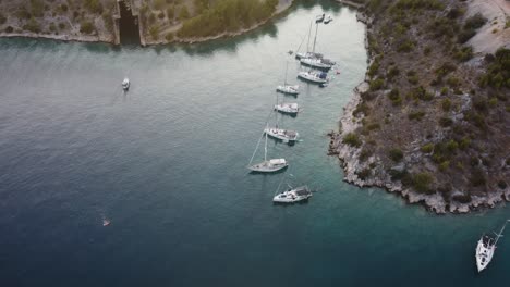 Aerial-view-of-a-wild-secluded-beach-at-the-coastline-of-Brac-Island,-Croatia,-Adriatic-Sea,-where-luxury-sailing-boats-are-anchored