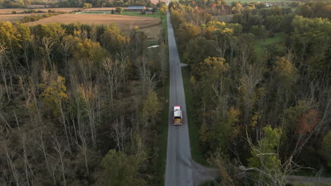 Aerial-Tracking-View-of-Emergency-Fire-Truck-Vehicle-Driving-Fast-along-Countryside-Road-with-Flashing-Lights,-Rescue-First-Responder-Mission-for-Fire-Fighting-or-Accident-Alert,-Landscape-Around