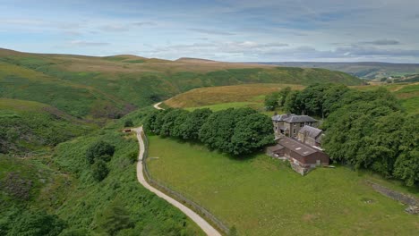 Drone-aerial-footage-of-Yorkshire-countryside-valleys-moorland-and-moving-slowly-up-a-footpath-towards-a-farmhouse-1