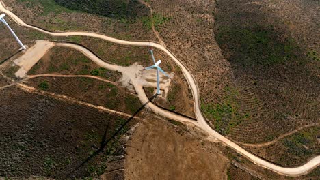 Aerial-topdown-view-of-wind-turbine-spinning-generating-energy,-mountain-landscape-in-northern-Chile