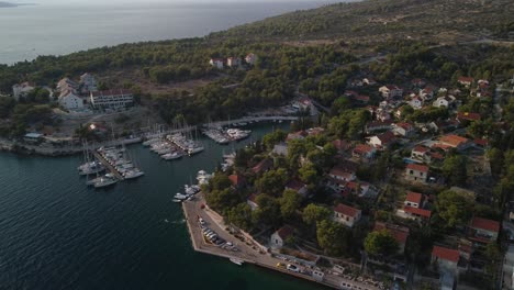 Aerial-orbit-shot,-port-in-Milna,-Brac-Island,-Croatia-at-sunset-with-scenic-view-over-the-turquoise-water-of-Adriatic-Sea