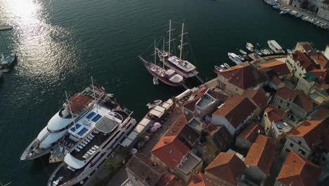 Close-up-drone-orbit-shot-of-cruis-ships-and-sailing-vessels-parked-in-Milna-Port,-Brac-Island,-Croatia