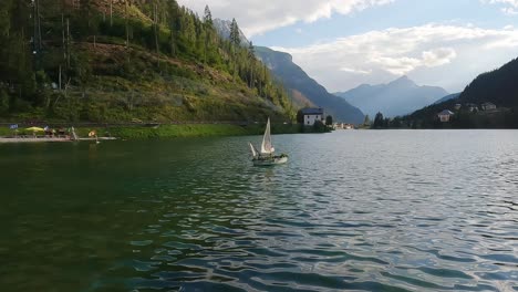 Decorative-boat-floating-on-Lake-Alleghe-in-the-Italian-Alps-on-a-beautiful-summer-day