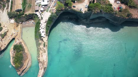 Cliff-rock-formation-with-tourist-sunbathing-in-stunning-European-beach-corfu-island-travel-holiday-destination