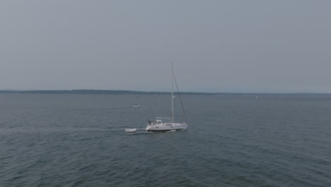 Aerial-footage-of-a-sailboat-sailing-through-the-cold-waters-outside-of-Seattle,-WA