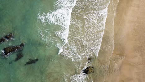 Blick-Von-Oben-Auf-Die-Schäumenden-Wellen,-Die-An-Der-Küste-Des-Lusty-Glaze-Beach-In-Newquay,-Großbritannien,-Rollen